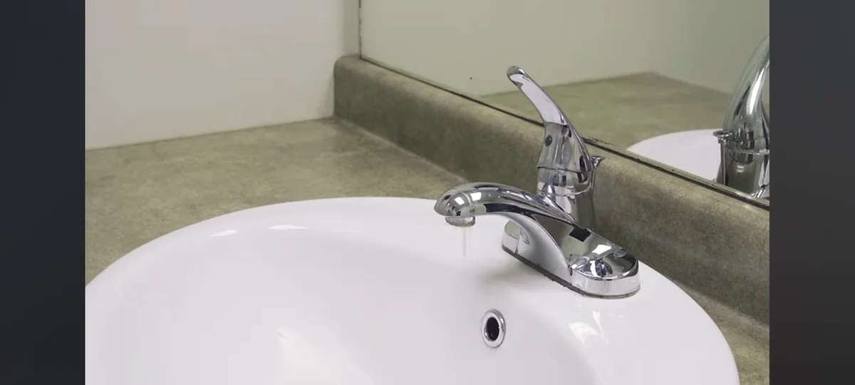 A bathroom hot-water tap running into a basin