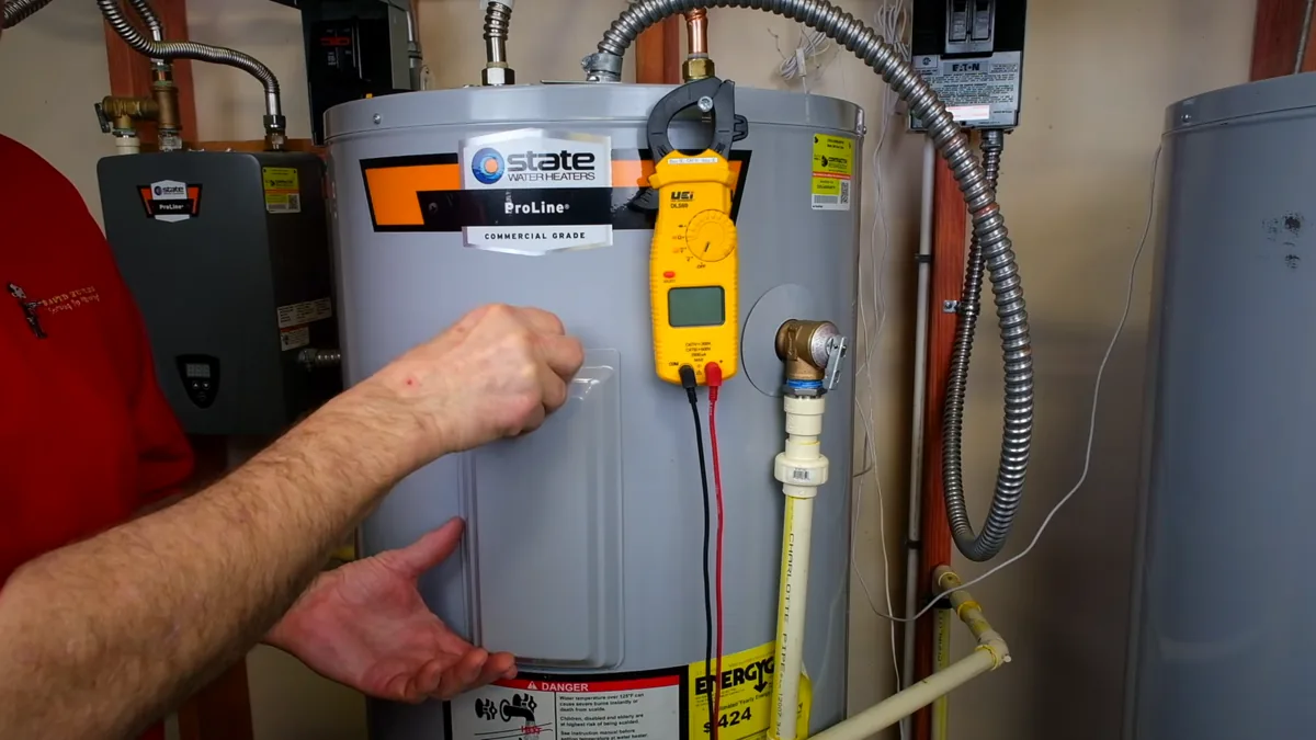Hands indicating pipe connections beside a storage heater
