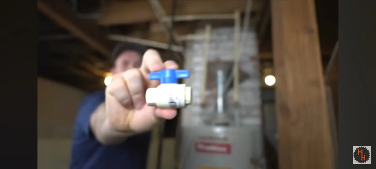 A small water heater control component held in front of the appliance